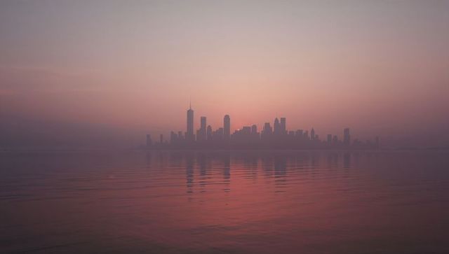 Serene Cityscape Silhouette with Reflective Sunrise