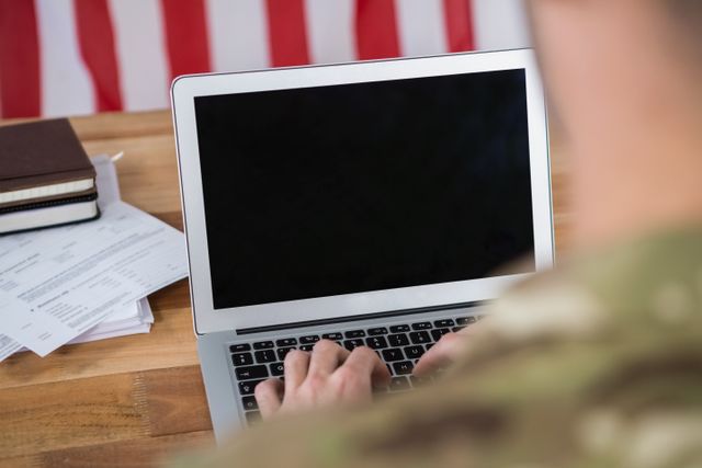 Rear view of soldier using a laptop