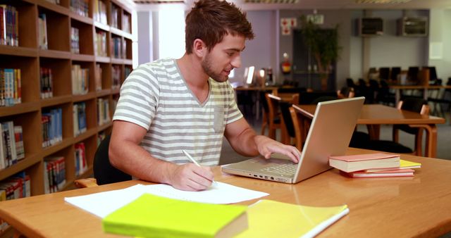 Young Man Studying on Laptop in Library Setting - Download Free Stock Images Pikwizard.com