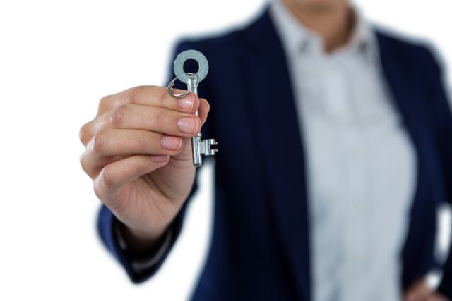 Businesswoman holding a new house key, symbolizing real estate success and property ownership. Ideal for use in real estate advertisements, business promotions, investment opportunities, and home buying guides.