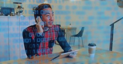 Talking asian man holding phone and tapping tablet at cafe table, coffee, coworking scene