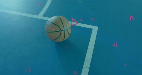 Resting basketball on blue court near white line casting long shadow with pink triangles