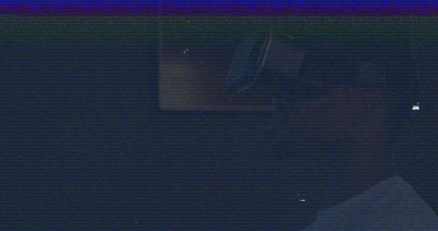 Person Engaging with Virtual Reality in Dimly Lit Room