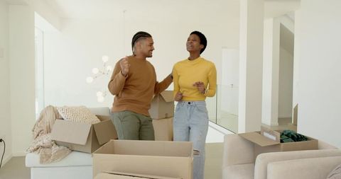 Diverse Couple Dancing Amongst Moving Boxes in New Home