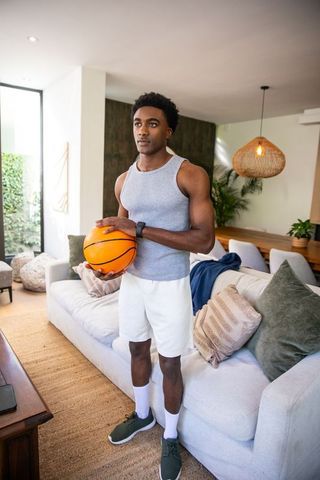Athletic Male Holding Basketball in Stylish Living Room
