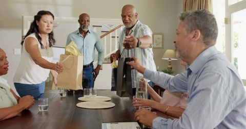 Diverse Senior Friends Exchanging Gifts at Celebration Table