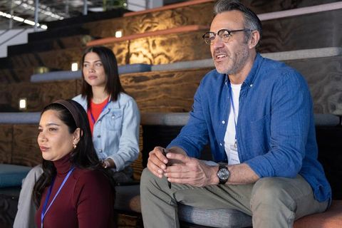 Diverse professionals listening on tiered seating during corporate workshop
