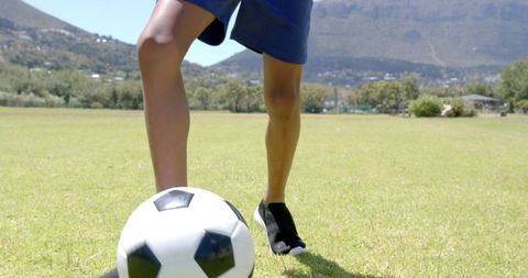 Youth Playing Soccer on Sunny Field with Mountain Backdrop