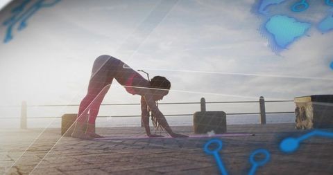 Silhouette woman stretching on waterfront boardwalk at sunrise with digital grid overlay for yoga