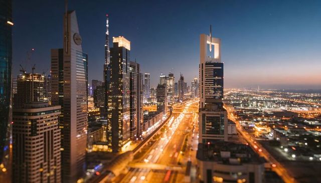 Dusk city light trails on busy urban highway amid glass skyscrapers aerial skyline