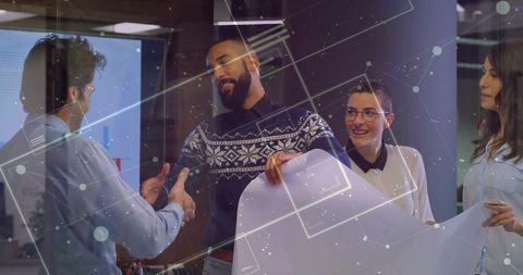 Colleagues reviewing blueprint in modern meeting room with digital overlay