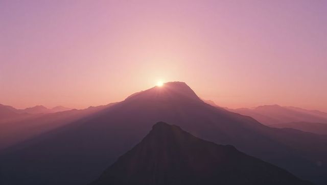 Serene Sunrise Casting Glows Over Misty Mountain Range