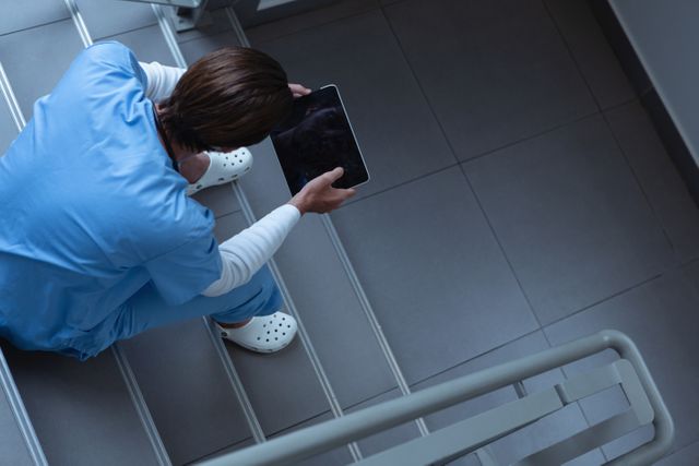 Male surgeon using digital tablet on stairs at hospital - Download Free Stock Photos Pikwizard.com