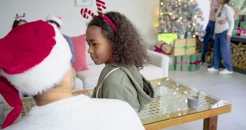 Multigenerational family celebrating Christmas at home, child wearing candy-cane headband