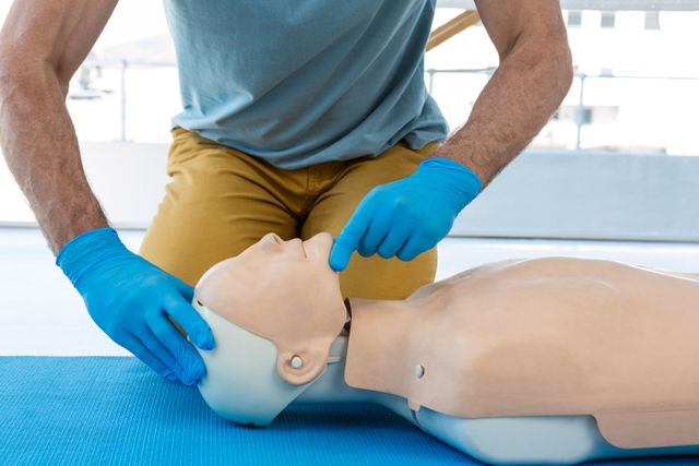 Mid section of paramedic practising resuscitation in clinic