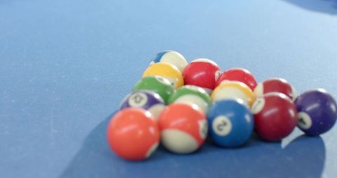 Colorful billiard balls forming triangle on blue felt showing 2-ball closeup and texture