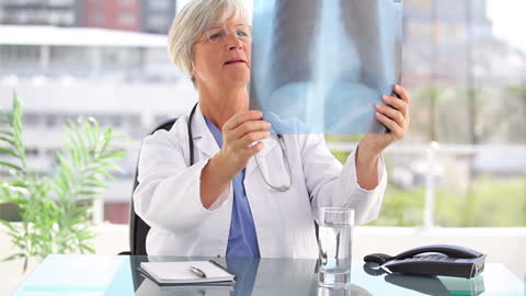 Senior Doctor Analyzing Chest X-ray in Modern Office Setting