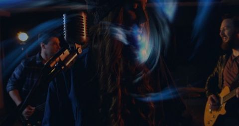 Live band performance with energetic female singer and vintage microphone