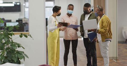 Team collaboration with masks in modern office setting