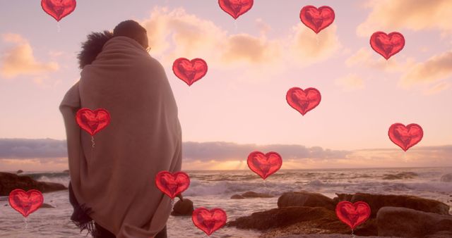 Image of red heart balloons floating over mid section of couple in love embracing by seaside. Happy Valentines Day celebration concept digitally generated image.