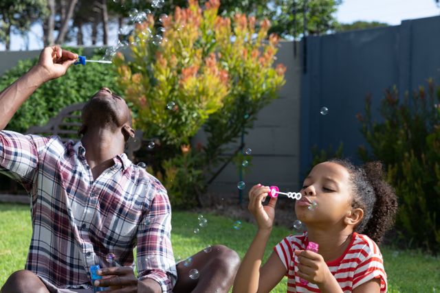 Father and Daughter Blowing Bubbles in Garden - Download Free Stock Images Pikwizard.com