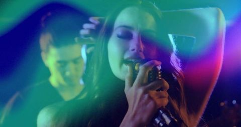 Singer Performing on Stage with Vibrant Lighting and Guitarist