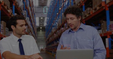 Warehouse Professionals Analyzing Data with Laptop