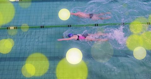 Competitive swimmers performing freestyle in pool