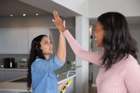 Women Celebrating Success by High-Fiving in Modern Kitchen