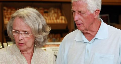 Senior couple selecting breads in grocery store