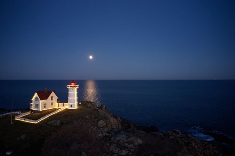 Idyllic Lighthouse and Cottage Illuminated by Moonlight