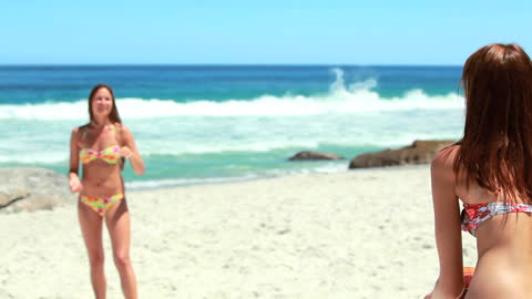Women Playing Beach Volleyball in Colorful Bikinis