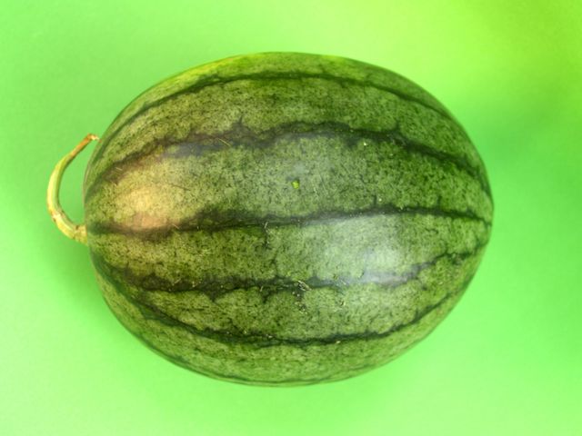 Perfectly Ripe Watermelon on Vibrant Green Background - Download Free Stock Photos Pikwizard.com