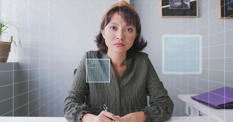 Focused professional asian woman in home office with digital elements