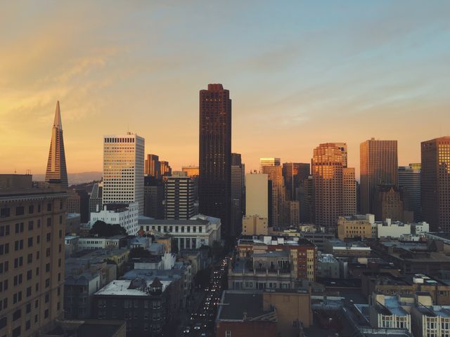 Panoramic view of San Francisco skyline showcasing city at sunset with iconic Transamerica Pyramid prominently visible. Perfect for travel blogs, city guides, real estate websites, and promotional material highlighting urban beauty.