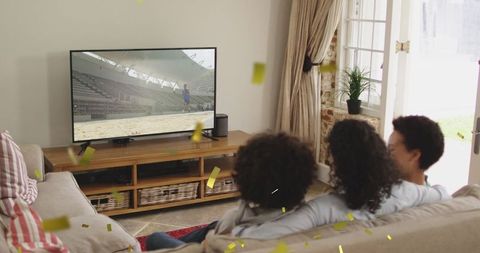 Joyful African American Family Watching TV with Confetti Celebration