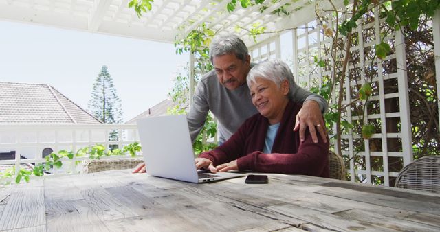 Senior Couple Using Laptop on Patio Surrounded by Greenery - Download Free Stock Images Pikwizard.com