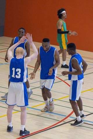 Diverse Basketball Players Celebrating Victory in Uniforms