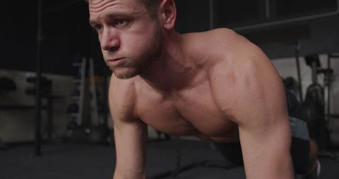 Focused athlete performing push-ups at gym