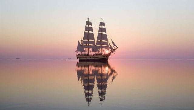 Moonlit sailboat on serene waters during sunset