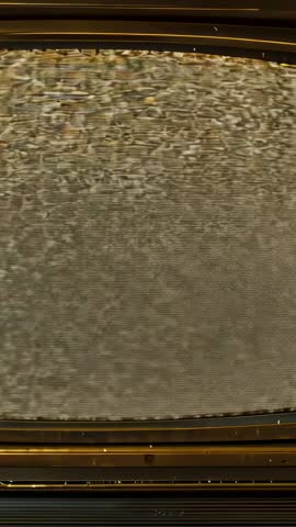 Vertical video zooming into CRT TV static and retro bezel showcasing vintage grain