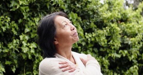 Senior Woman Contemplating in Serene Garden Setting