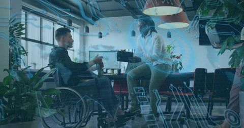 Businesswoman Assisting Coworker in Wheelchair with Technology