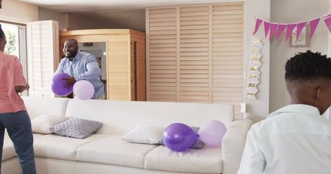 African american family laughing and celebrating birthday party in bright living room