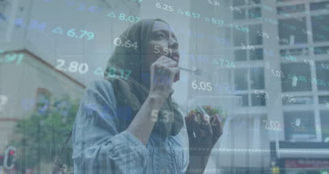 Woman in Hijab Enjoys Snack Amidst Financial Trends Reflection