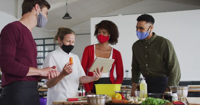 Chefs Wearing Masks Collaborating in Kitchen with Tablet and Fresh Ingredients - Download Free Stock Images Pikwizard.com