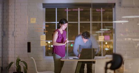 Focused Business Team Collaborating in Office at Night