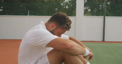 Tennis Player Recovering from Intense Match on Court