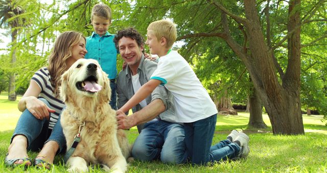 Young family of four with their dog enjoying quality time in a green park on a sunny day. Great for concepts related to family bonding, pet-friendly outdoors, and leisure activities.