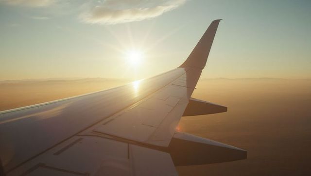 Sunlit Airplane Wing at High Altitude During Golden Hour